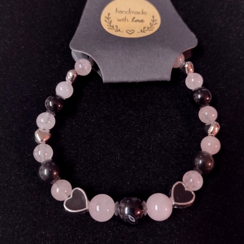 Rose quartz an variegated black agates with onyx and silver heart shaped beads .